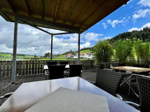 苏尔茨贝格Pension & Gasthof zur Taube的庭院配有白色桌椅和围栏