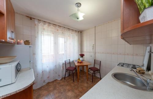 基辅Затишна квартира в центрі Оболоні м Київ的厨房配有桌椅和水槽。