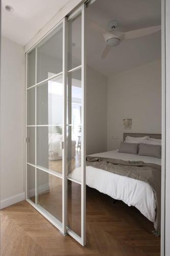 马德里DELUXE APARTMENT NEAR GRAN VIA的一间卧室设有一张床和一个滑动玻璃门