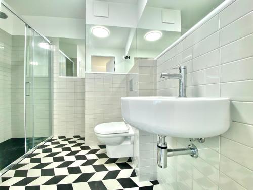 克拉科夫H11 Aparthotel的白色的浴室设有水槽和卫生间。