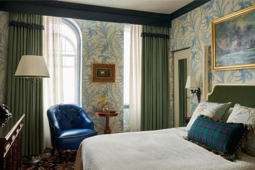 特伦Marine Troon的一间卧室配有一张床和一张蓝色椅子