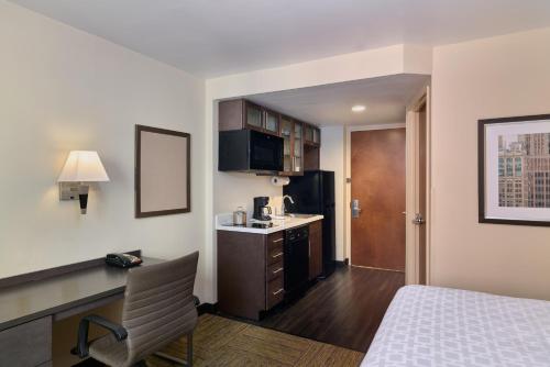 纽约纽约时代广场烛木套房酒店的酒店客房配有一张床、一张书桌和一间厨房。