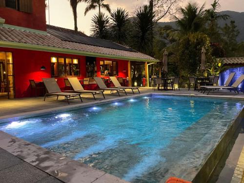 马利西亚斯马利西亚斯庞萨达雷富吉酒店的一个带椅子的游泳池以及一座房子