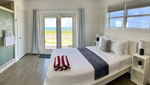 弗拉格勒海滩A1A Ocean Club的白色卧室设有一张大床和窗户