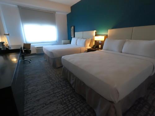 瓜亚尼亚Costa Bahia Hotel, Convention Center and Casino的酒店客房设有两张床和窗户。