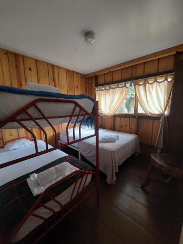 Bajo BoqueteHostal Vista Boquete的一间卧室设有两张双层床和一扇窗户。