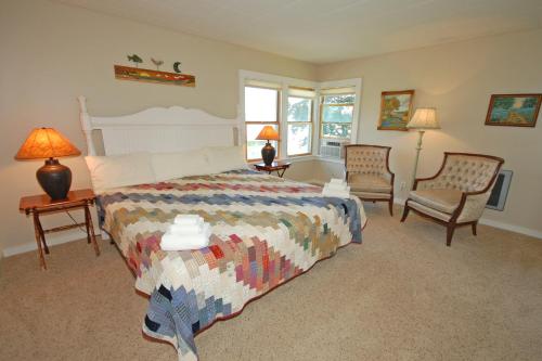 格伦阿伯Lone Star Escape的一间卧室配有一张床、两把椅子和两盏灯。