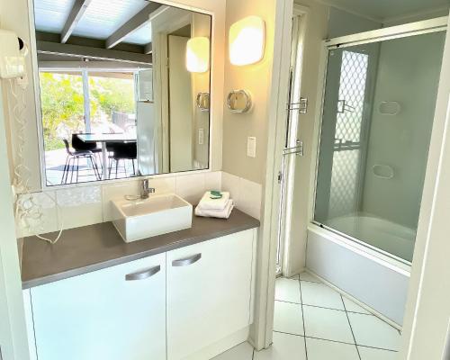 巴加拉凯利海滩度假酒店的一间带水槽、镜子和桌子的浴室