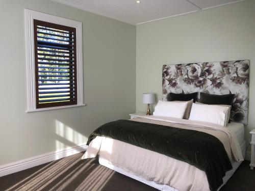 KahuranakiRiver View Cottage的白色的卧室设有一张大床和一个窗户
