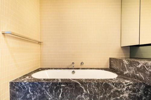 墨尔本Luxury beachside apartment的一间带水槽和瓷砖墙的浴室