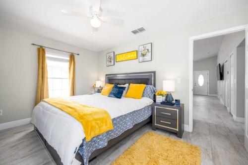 坦帕Modern Luxury Home Located in Tampa!的一间卧室配有一张大床,提供黄色和蓝色的枕头