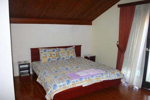 特佩杰卡Villa Filip的一间卧室配有一张带木制床头板的床