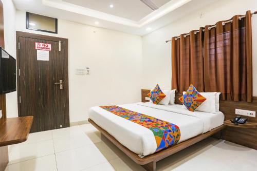 印多尔FabHotel Balaji Paradise的一间卧室配有一张床和一扇木门