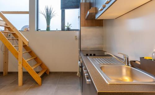 列日Le Studio Compostelle by Maison Brasseurs d'Etoiles的一个带水槽和楼梯的厨房