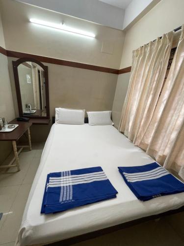 班加罗尔Golden Guest House的一间卧室配有一张带蓝色和白色毛巾的床