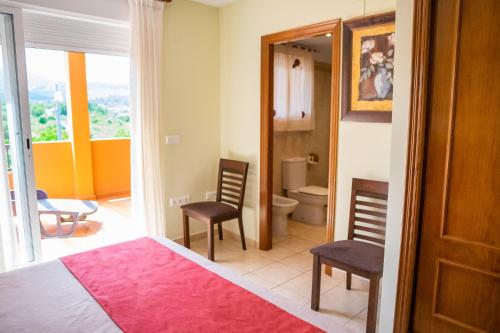 佩尼斯科拉Montemar Natura Resort的一间卧室配有一张床和两把椅子,还有一间浴室