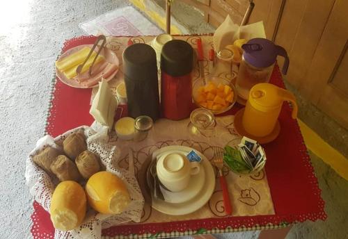 伊利亚贝拉Suítes Cocaia的一张桌子,早餐包括面包和水果