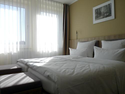 明斯特叶兰特鲁普酒店的卧室设有2张大型白色床和窗户