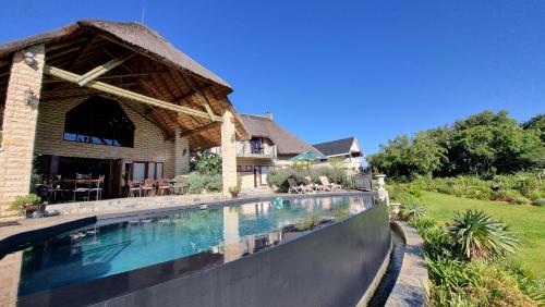 香槟谷Inkungu Lodge的房屋前的游泳池