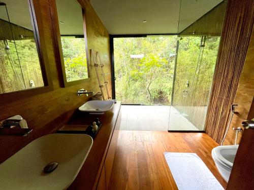 KalawanaKurunduketiya Private Rainforest Resort的带浴缸、水槽和镜子的浴室
