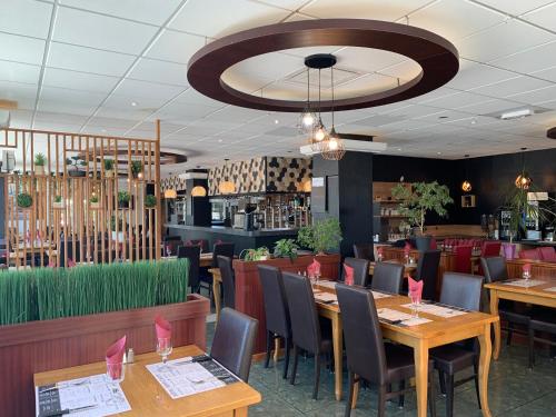 第戎Hôtel Restaurant Kyriad Direct DIJON NORD - Zenith - Toison d'Or的用餐室配有木桌和椅子