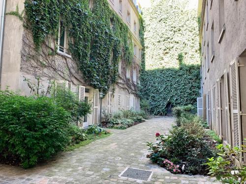 巴黎Chambre d’hôtes - Marais的一座楼边长着常春藤的小巷
