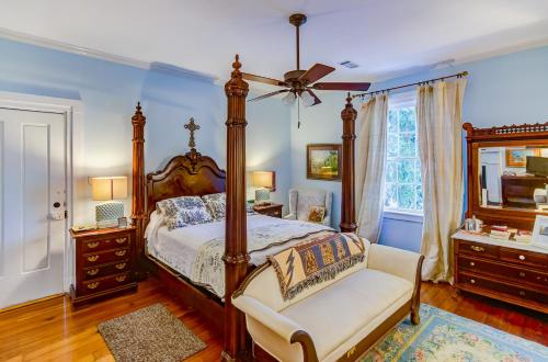 维克斯堡Steele Cottage的一间卧室配有一张天蓬床和一把椅子