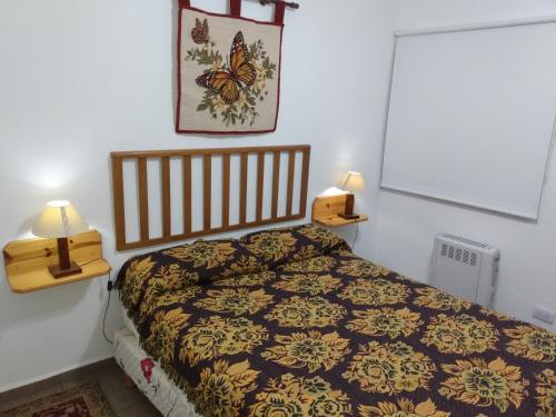 拉博尔萨El Tatu的卧室配有一张床,墙上配有两盏灯。