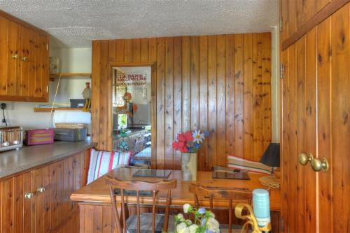 查茅斯Willows的厨房设有木墙和桌椅