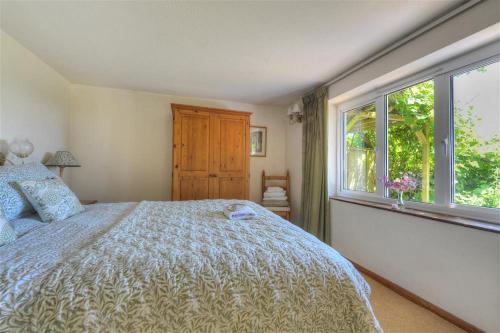 查茅斯Willows的一间卧室设有一张大床和一个窗户。