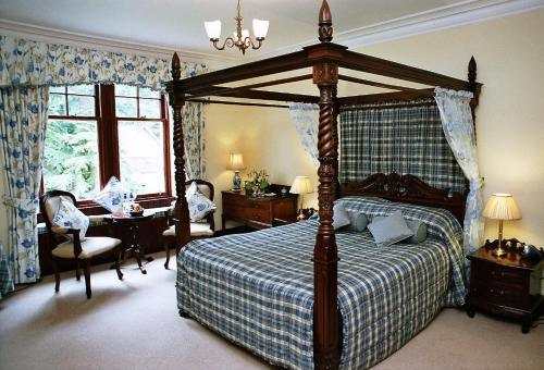 斯佩河畔格兰敦缇娜斯格特斯乡村房屋酒店的一间卧室配有一张大天蓬床和一张书桌