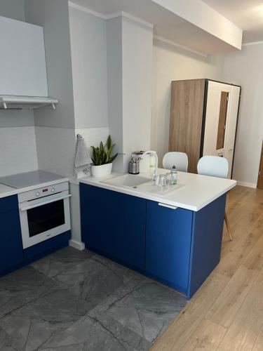 卡托维兹Marcinkowskiego 11 - 2的厨房配有蓝色橱柜和白色台面
