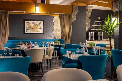 莱德萨阿尔卑斯Hôtel Aalborg的一间设有蓝色椅子和桌子的餐厅