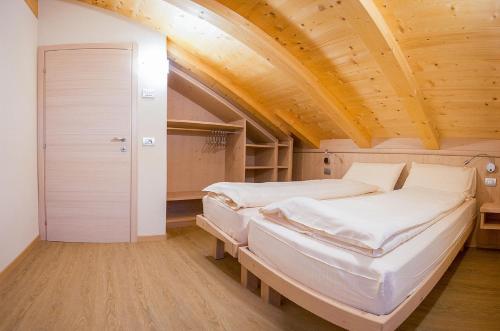 利维尼奥Chalet Alaska的配有木天花板的客房内的两张床