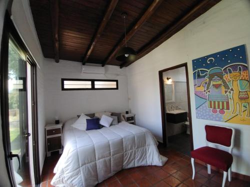 圣萨尔瓦多德朱CampoMora- 5 min del Centro - CONFORT - Parrilla & Pileta的卧室配有一张床,墙上挂有绘画作品