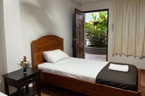 马尔多纳多港Hotel Principe I的一间卧室配有一张床、一张桌子和一个窗户。