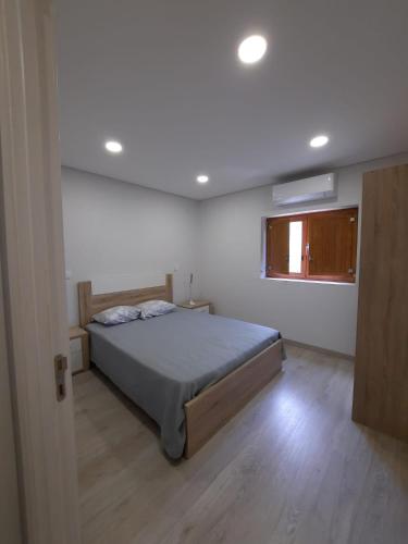 Rio CaldoCasa dos Moroucinhos的一间卧室设有一张大床和一个窗户。