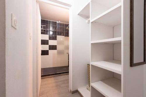 库鲁Villa Comfort-Soleil的浴室内带白色架子的步入式衣柜