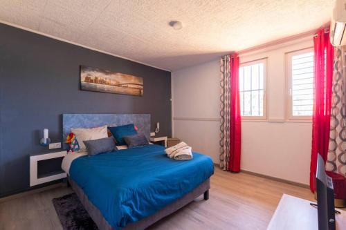 库鲁Villa Comfort-Soleil的一间卧室配有蓝色的床和红色窗帘