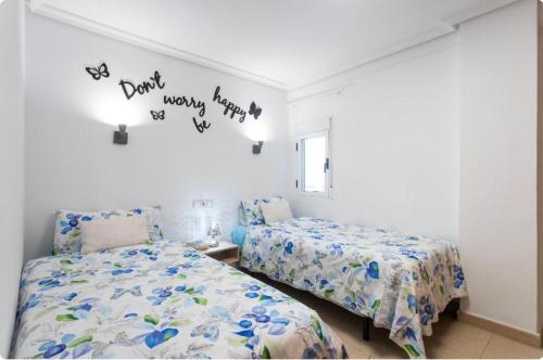 贝尼多姆Payma Apartments Benidorm的卧室配有两张床,墙上写着字条