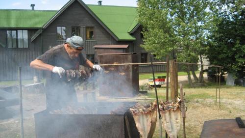 帕维洛斯塔维苏玛雅兹维尼斯酒店的一个人在烧烤架上做饭