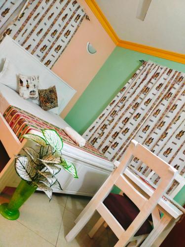 蒙巴萨Phee home的一间卧室,卧室内配有一张床和一把椅子