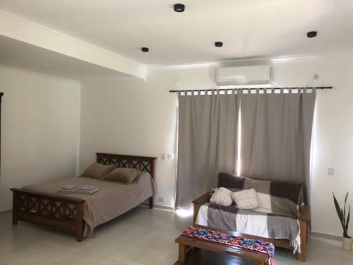 波萨达斯Wawa Estudio的一间卧室配有一张床、一张沙发和一个窗口