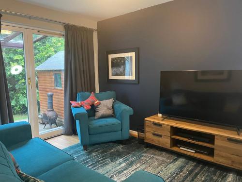阿维莫尔Linmore的客厅配有蓝色的沙发和平面电视。