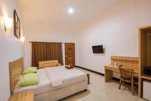 圣吉吉Central Inn Senggigi的一间卧室配有一张床、一张桌子和一张桌子