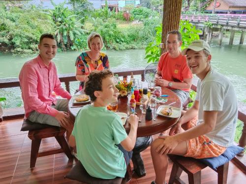 考索Khao Sok River & Jungle Resort的一群坐在桌子旁吃食物的人