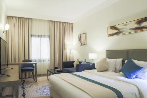 阿可贺巴Safwat Alkhobar Hotel的配有一张床和一张书桌的酒店客房