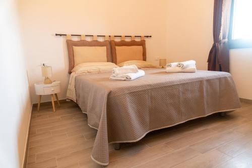 潘泰莱里亚Dammusu di Turì的一间卧室配有一张床,上面有两条毛巾