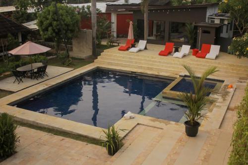 哲帕拉Lucca Resort & Residence的庭院内一个带椅子和桌子的游泳池