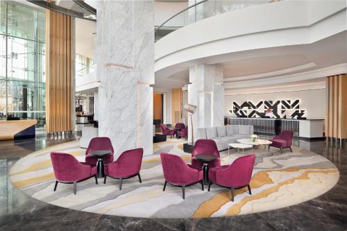 吉达Crowne Plaza - Jeddah Al Salam, an IHG Hotel的大堂设有粉红色的椅子和沙发